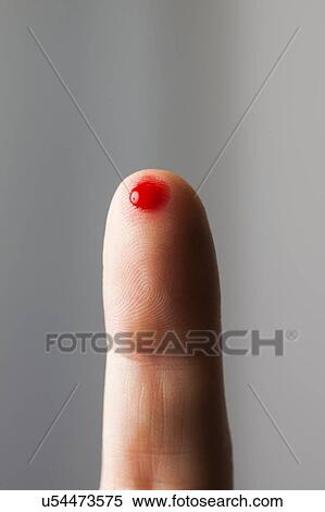Stock Photography - MODEL RELEASED. Blood on fingertip, close up.. Fotosearch