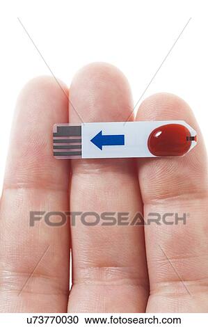 Stock Image - MODEL RELEASED. Blood sample on glucose test strip, studio shot.. Fotosearch