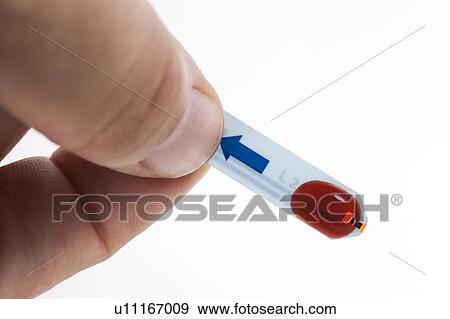 Stock Photo - MODEL RELEASED. Blood sample on glucose test strip, studio shot.. Fotosearch