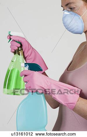 MODEL RELEASED. Close-up of woman wearing face mask holding cleaning materials in her gloved hands. View Large Photo Image Stock Image - MODEL RELEASED. Close-up of woman wearing face mask holding cleaning materials in her gloved hands.. Fotosearch