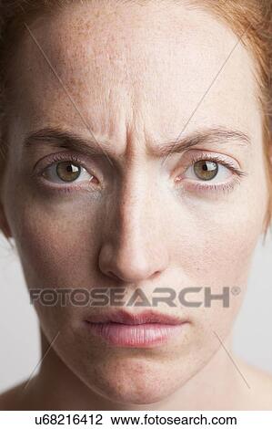 Stock Image - MODEL RELEASED. Close-up of young woman looking angry.. Fotosearch