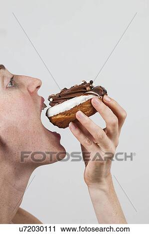 MODEL RELEASED. Close-up profile of woman eating chocolate doughnut. View Large Photo Image Stock Image - MODEL RELEASED. Close-up profile of woman eating chocolate doughnut.. Fotosearch