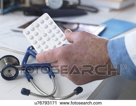 MODEL RELEASED. Doctor holding a strip of drugs ready to hand out to his patient. View Large Photo Image Stock Image - MODEL RELEASED. Doctor holding a strip of drugs ready to hand out to his patient.. Fotosearch