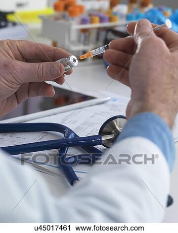 MODEL RELEASED. Doctor preparing a syringe ready for injection. View Large Photo Image Stock Image - MODEL RELEASED. Doctor preparing a syringe ready for injection.. Fotosearch