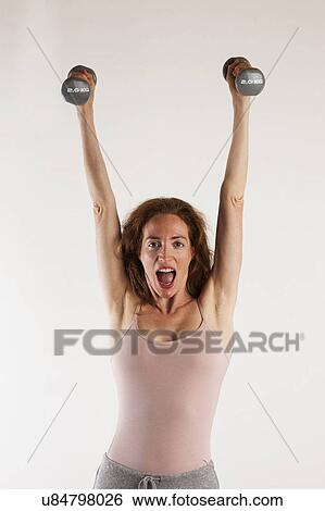 MODEL RELEASED. Happy, strong woman exercising with dumb bells. View Large Photo Image Stock Photograph - MODEL RELEASED. Happy, strong woman exercising with dumb bells.. Fotosearch