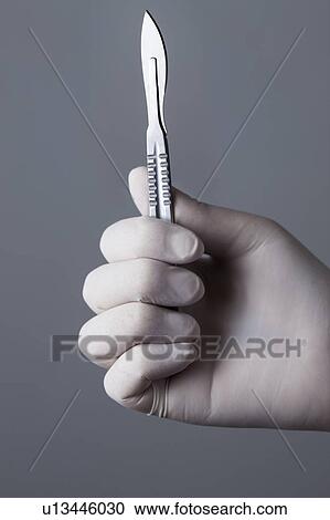 MODEL RELEASED. Person wearing latex glove holding scalpel. View Large Photo Image Stock Image - MODEL RELEASED. Person wearing latex glove holding scalpel.. Fotosearch