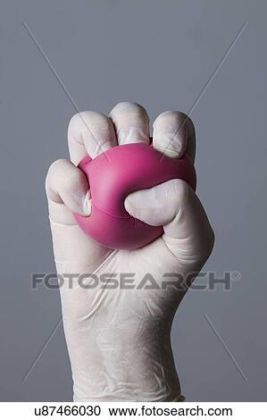 MODEL RELEASED. Person wearing latex glove holding stress ball. View Large Photo Image Stock Image - MODEL RELEASED. Person wearing latex glove holding stress ball.. Fotosearch