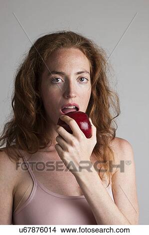 MODEL RELEASED. Portrait of woman eating red apple as part of a healthy diet. View Large Photo Image Picture - MODEL RELEASED. Portrait of woman eating red apple as part of a healthy diet.. Fotosearch