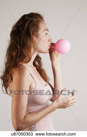 MODEL RELEASED. Profile of young woman with red hair blowing up pink balloon. View Large Photo Image Stock Image - MODEL RELEASED. Profile of young woman with red hair blowing up pink balloon.. Fotosearch