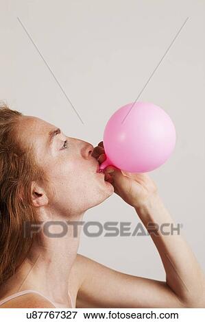 MODEL RELEASED. Profile of young woman with red hair blowing up pink balloon. View Large Photo Image Stock Photo - MODEL RELEASED. Profile of young woman with red hair blowing up pink balloon.. Fotosearch