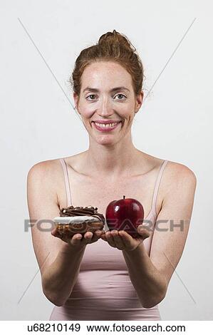 Stock Photo - MODEL RELEASED. Smiling woman making diet choices.. Fotosearch