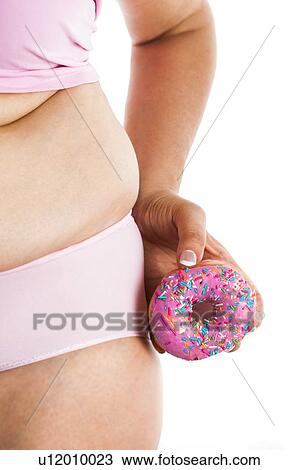 Stock Image - MODEL RELEASED. Woman holding doughnut by hips.. Fotosearch