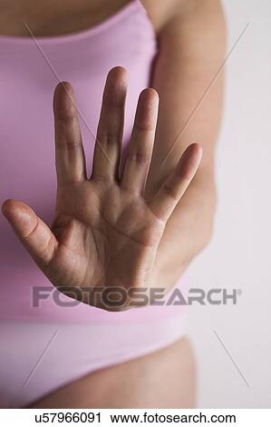 Stock Image - MODEL RELEASED. Woman holding hand out towards camera.. Fotosearch