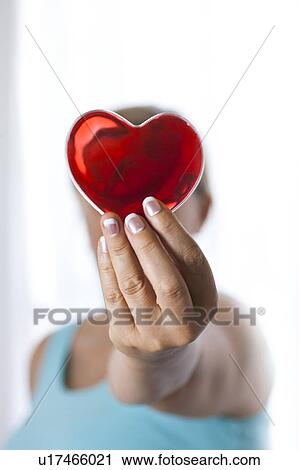 MODEL RELEASED. Woman holding red heart in front of her face. View Large Photo Image Stock Image - MODEL RELEASED. Woman holding red heart in front of her face.. Fotosearch