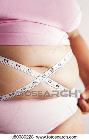 MODEL RELEASED. Woman measuring waist with tape measure. View Large Photo Image Stock Photo - MODEL RELEASED. Woman measuring waist with tape measure.. Fotosearch