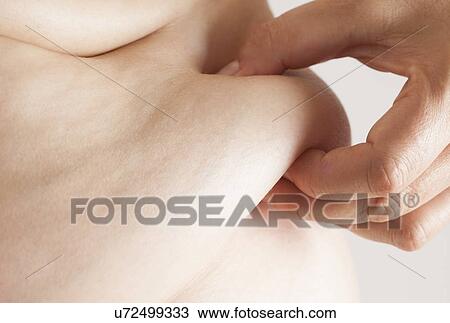 MODEL RELEASED. Woman pinching flesh on her waist, close up. View Large Photo Image Stock Image - MODEL RELEASED. Woman pinching flesh on her waist, close up.. Fotosearch