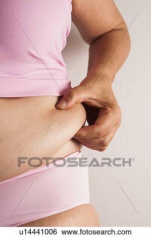 MODEL RELEASED. Woman pinching flesh on her waist. View Large Photo Image Stock Photograph - MODEL RELEASED. Woman pinching flesh on her waist.. Fotosearch