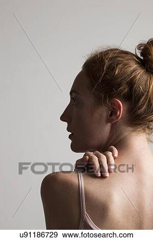 MODEL RELEASED. Woman touching her neck and back, head in profile. View Large Photo Image Stock Photo - MODEL RELEASED. Woman touching her neck and back, head in profile.. Fotosearch