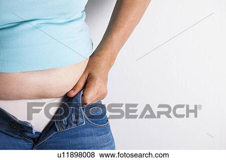 MODEL RELEASED. Woman trying to do up her jeans. View Large Photo Image Stock Photo - MODEL RELEASED. Woman trying to do up her jeans.. Fotosearch