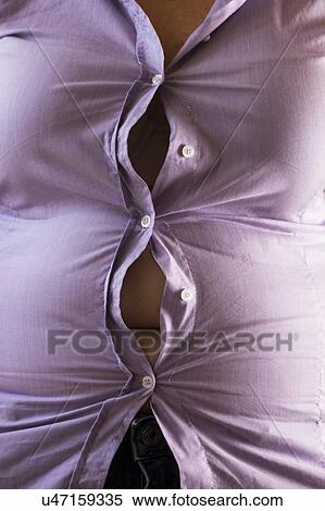Stock Photography - MODEL RELEASED. Woman wearing tight purple shirt with the buttons opening.. Fotosearch