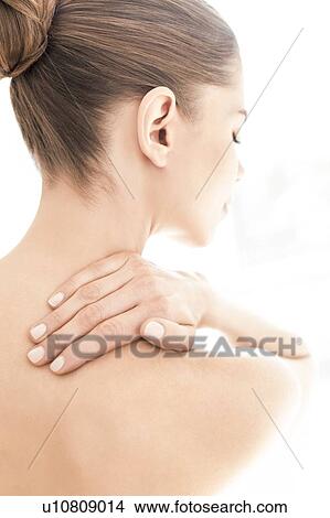 Picture - MODEL RELEASED. Young topless woman in pain touching her neck.. Fotosearch