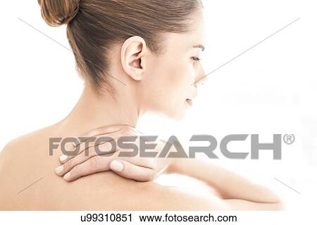 Stock Image - MODEL RELEASED. Young topless woman in pain touching her neck.. Fotosearch