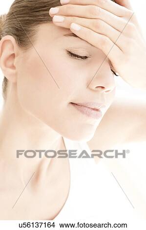 Picture - MODEL RELEASED. Young woman in pain with headache, close up.. Fotosearch