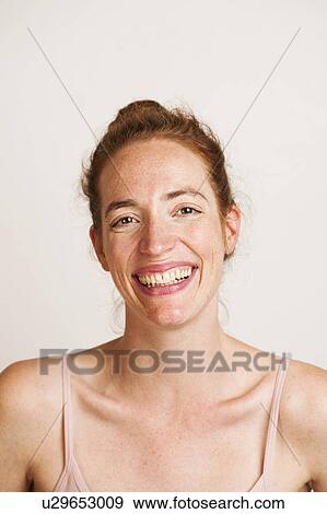 Stock Photo - MODEL RELEASED. Young woman with red hair smiling.. Fotosearch