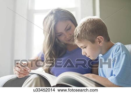 Mother and son reading a book together. View Large Photo Image Picture - Mother and son reading a book together.. Fotosearch