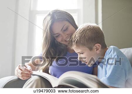 Stock Image - Mother and son reading a book together.. Fotosearch