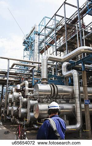Stock Image - Oil and gas worker inside refinery.. Fotosearch