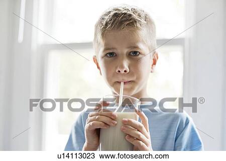 Portrait of a young boy drinking milk through a straw. View Large Photo Image Stock Image - Portrait of a young boy drinking milk through a straw.. Fotosearch