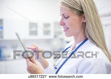 Stock Photo - Portrait of female doctor using digital tablet.. Fotosearch