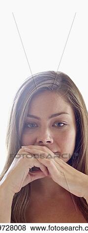 Stock Photo - Portrait of young woman with hands covering mouth.. Fotosearch