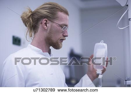 Stock Photo - Radiologist holding solution bottle. Fotosearch