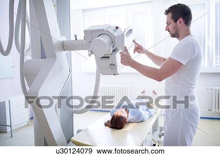 Stock Photo - Radiologist positioning x-ray machine.. Fotosearch