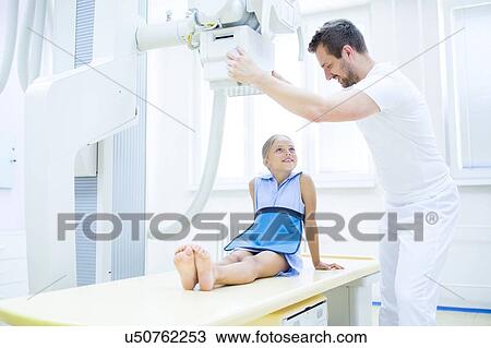 Radiologist preparing young girl for x-ray in hospital. View Large Photo Image Stock Image - Radiologist preparing young girl for x-ray in hospital.. Fotosearch