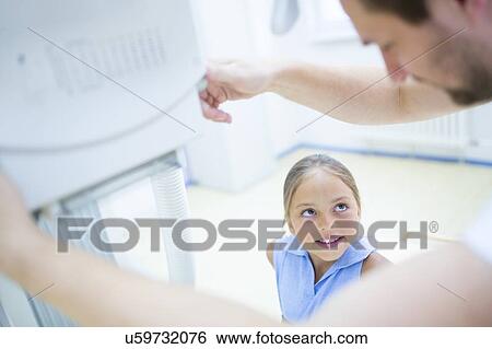 Stock Photograph - Radiologist preparing young girl for x-ray in hospital.. Fotosearch