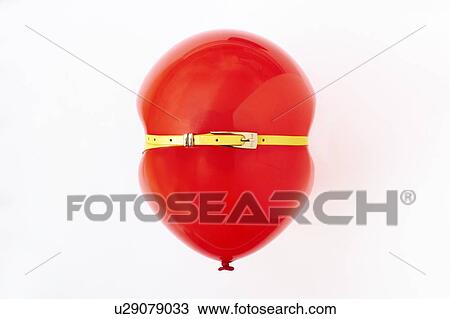 Stock Image - Red balloon, conceptual image of bloated stomach. Fotosearch
