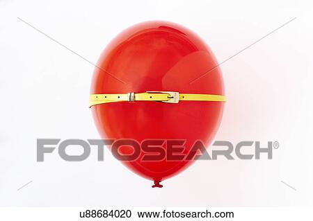 Stock Image - Red balloon, conceptual image of bloated stomach. Fotosearch
