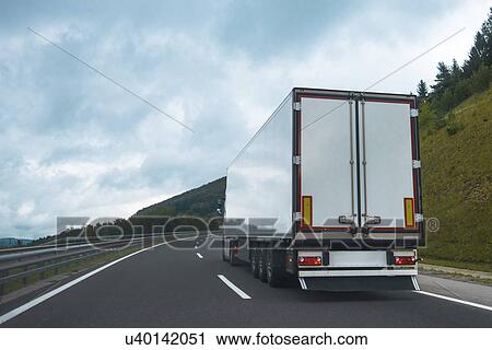 Stock Image - Semi truck with trailer on highway road. Fotosearch