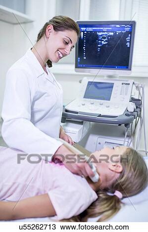 Sonographer performing ultrasound on girl. View Large Photo Image Stock Image - Sonographer performing ultrasound on girl.. Fotosearch