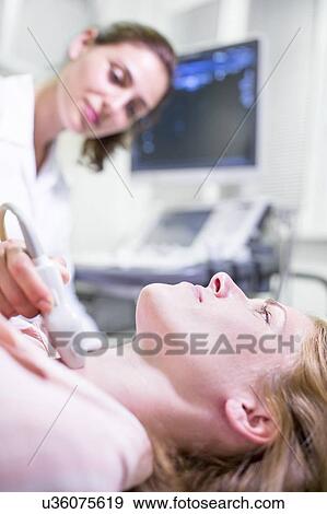 Sonographer performing ultrasound on female patient. View Large Photo Image Stock Photo - Sonographer performing ultrasound on female patient.. Fotosearch