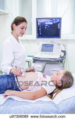 Sonographer performing ultrasound on young girl. View Large Photo Image Stock Photo - Sonographer performing ultrasound on young girl.. Fotosearch