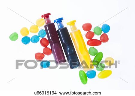 Picture - Three containers with red, blue and yellow liquid spots, studio shot.. Fotosearch