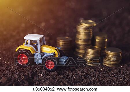 Toy tractor with stacked coins, conceptual image View Large Photo Image Stock Image - Toy tractor with stacked coins, conceptual image. Fotosearch
