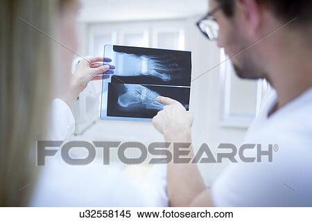Stock Photography - Two doctors holding x-ray of human foot.. Fotosearch