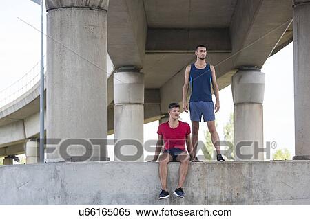 Stock Photography - Two male athletes under concrete bridge.. Fotosearch