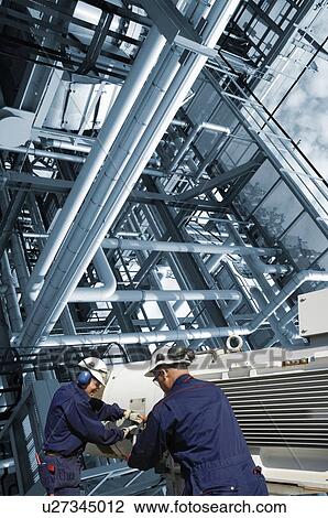 Two refinery workers with pump machinery. View Large Photo Image Stock Image - Two refinery workers with pump machinery.. Fotosearch