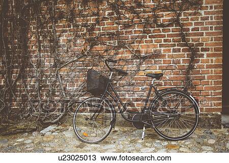 Vintage bicycle leaning against wall View Large Photo Image Stock Image - Vintage bicycle leaning against wall. Fotosearch